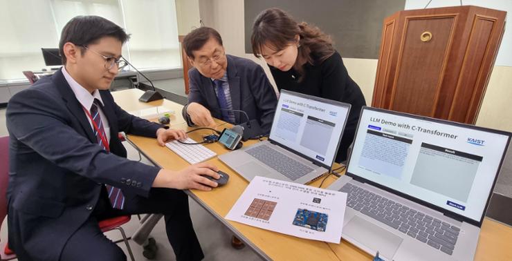Yoo Hoi-jun, center, a KAIST professor, and Kim Sang-yeob, left, a member of Yoo's research team, demonstrate a neuromorphic AI semiconductor that uses computing technology mimicking the behavior of the human brain at the ICT ministry's headquarters in Sejong, Wednesday. Yonhap