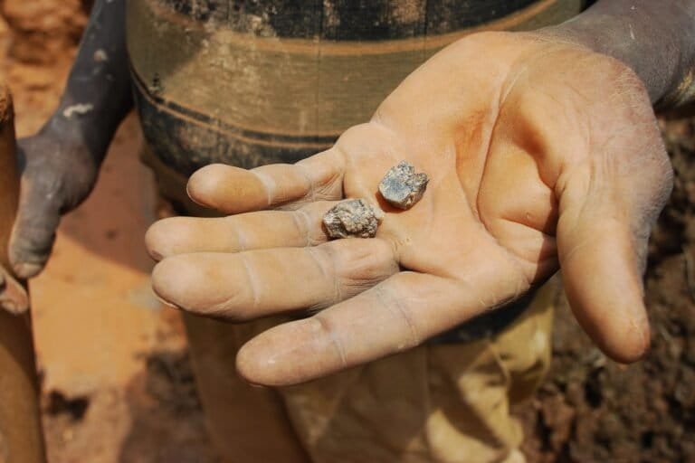 An artisanal miner in North Kivu holds cassiterite crystals, from which tin can be extracted: young people in Manono also dig for this mineral to sell to traders. Image by Laura Heaton/Enough Project via Flickr (CC BY-NC-ND 2.0). An artisanal miner in North Kivu holds cassiterite crystals, from which tin can be extracted: young people in Manono also dig for this mineral to sell to traders. Image by Laura Heaton/Enough Project via Flickr (CC BY-NC-ND 2.0).